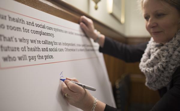 Woman signing Care for Tomorrow pledge board