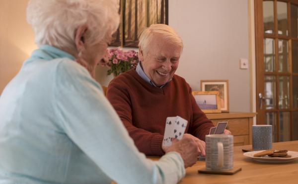 Smiling man and woman playing cards