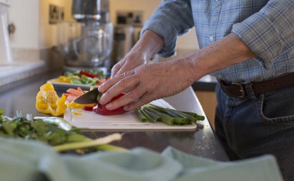 Man's hands chopping vegetables in a kitchen