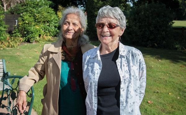 Two women smiling in garden