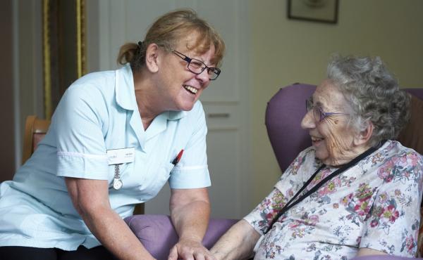 Older woman with paid carer in care home