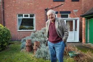 Older man smiling in a garden