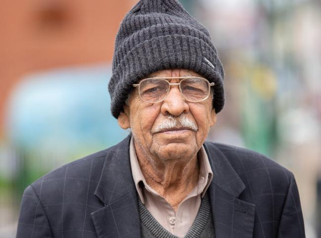 Older man facing camera wearing a hat