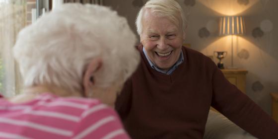 An older man and woman laughing together