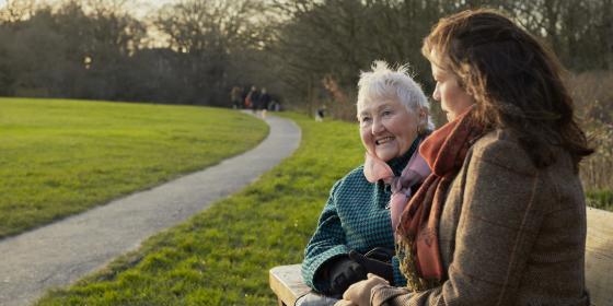 Older women laughing on a park bench