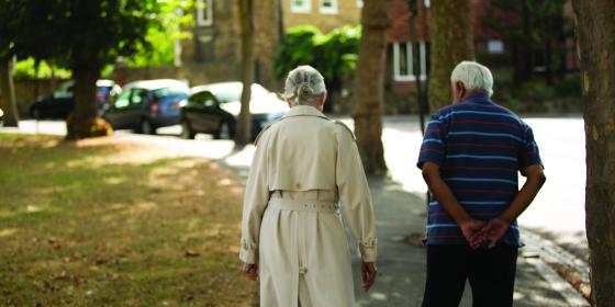 An older woman and man walking together outside
