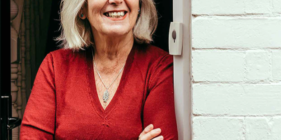 An image of the report cover showing an older woman leaning against her doorframe smiling.