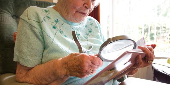 Woman using magnifying glass to read
