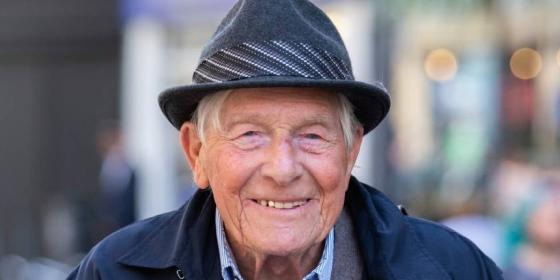 Older man wearing hat and smiling