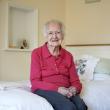 An older woman on her bed smiling