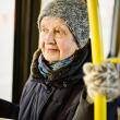 Older woman wearing hat and gloves on bus