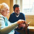 Older woman with younger man using a tablet