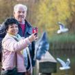 Woman and man take a selfie with a smartphone in a park