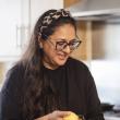 Woman peeling vegetable in kitchen