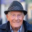 Older man wearing hat and smiling