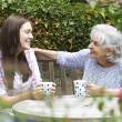 Younger and older woman talking and smiling in a garden