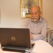 An older man uses a computer in his home