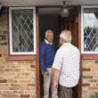 Homeowner speaking to man on doorstep