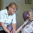 Older woman and paid carer in care home
