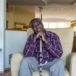 Man sitting in armchair with walking stick