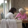 Two older women play chess together