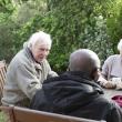 Three older people sat outside talking