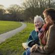 Older women laughing on a park bench