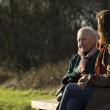 Older and younger woman talking on a park bench